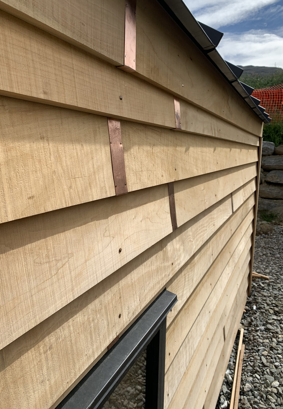 Timber weatherboard cladding with copper flashing